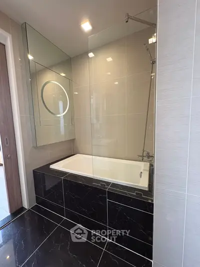 Luxurious modern bathroom with sleek black tiles and elegant bathtub