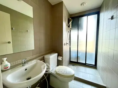 Modern bathroom with sleek shower and contemporary fixtures in a stylish apartment.