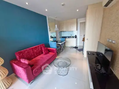 Modern living room with vibrant red sofa and open kitchen layout