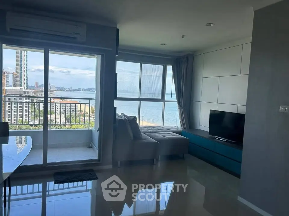 Modern living room with stunning ocean view and spacious balcony access.