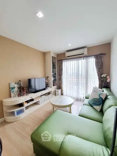 Cozy living room with green sofa and TV, perfect for relaxation
