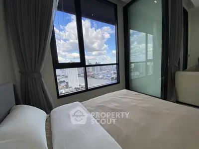 Modern bedroom with large window offering stunning city view and natural light