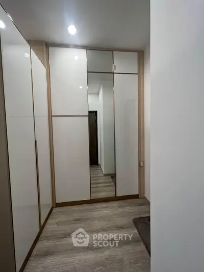 Modern hallway with sleek built-in wardrobes and wooden flooring