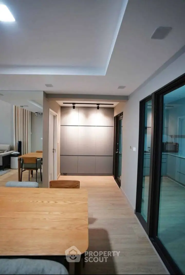 Modern open-plan living area with sleek dining table and stylish lighting, perfect for contemporary living.
