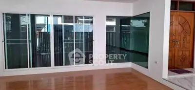 Spacious interior with large windows and elegant wooden door, perfect for modern living.