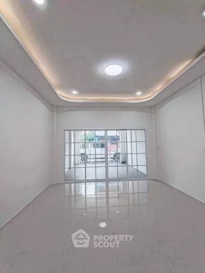 Spacious modern living room with elegant ceiling lights and large sliding glass doors.