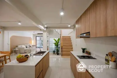 Modern open-plan kitchen and living area with wooden cabinetry and sleek design