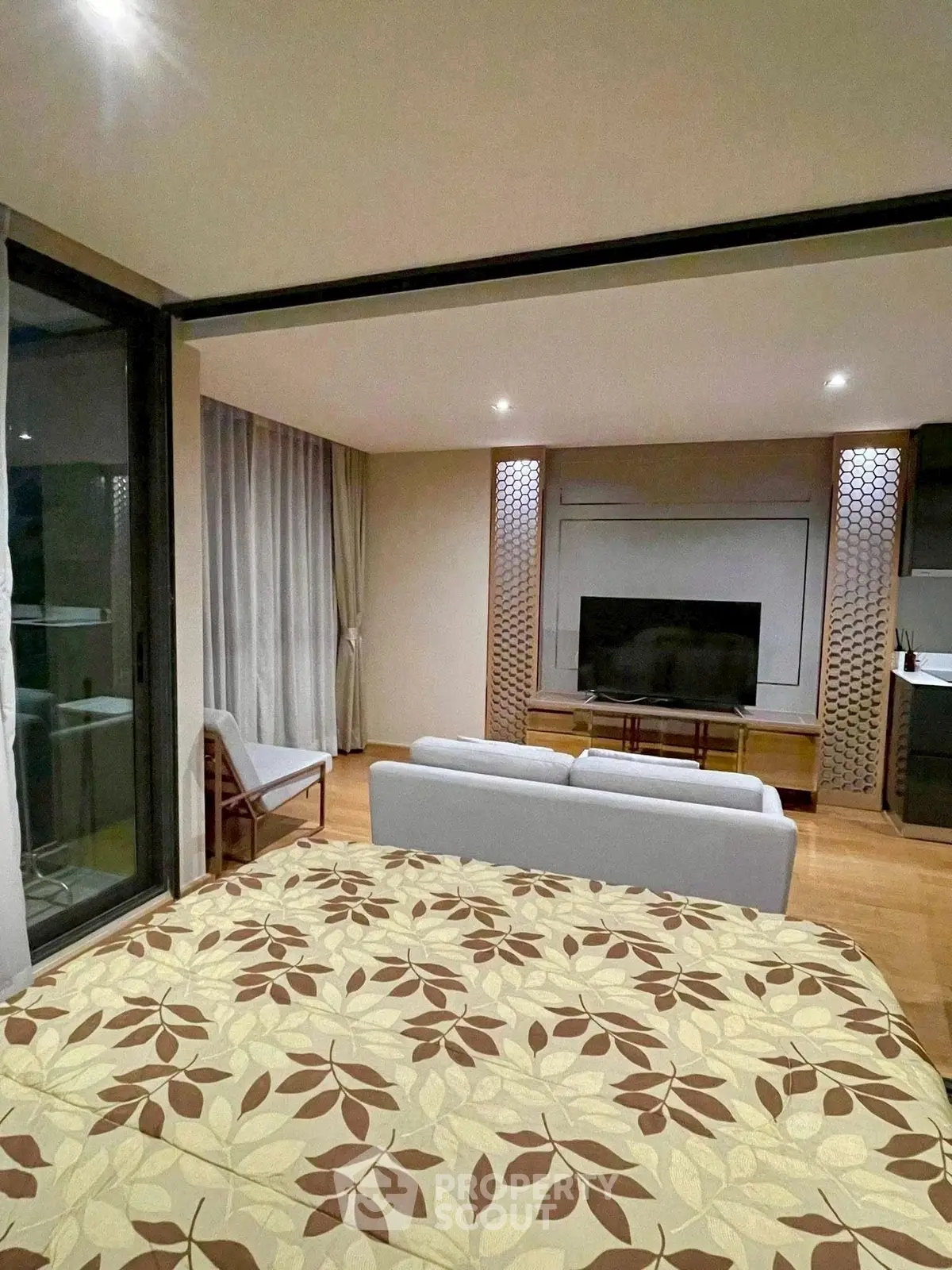 Modern living room with stylish decor and large TV, featuring a cozy seating area and elegant lighting.