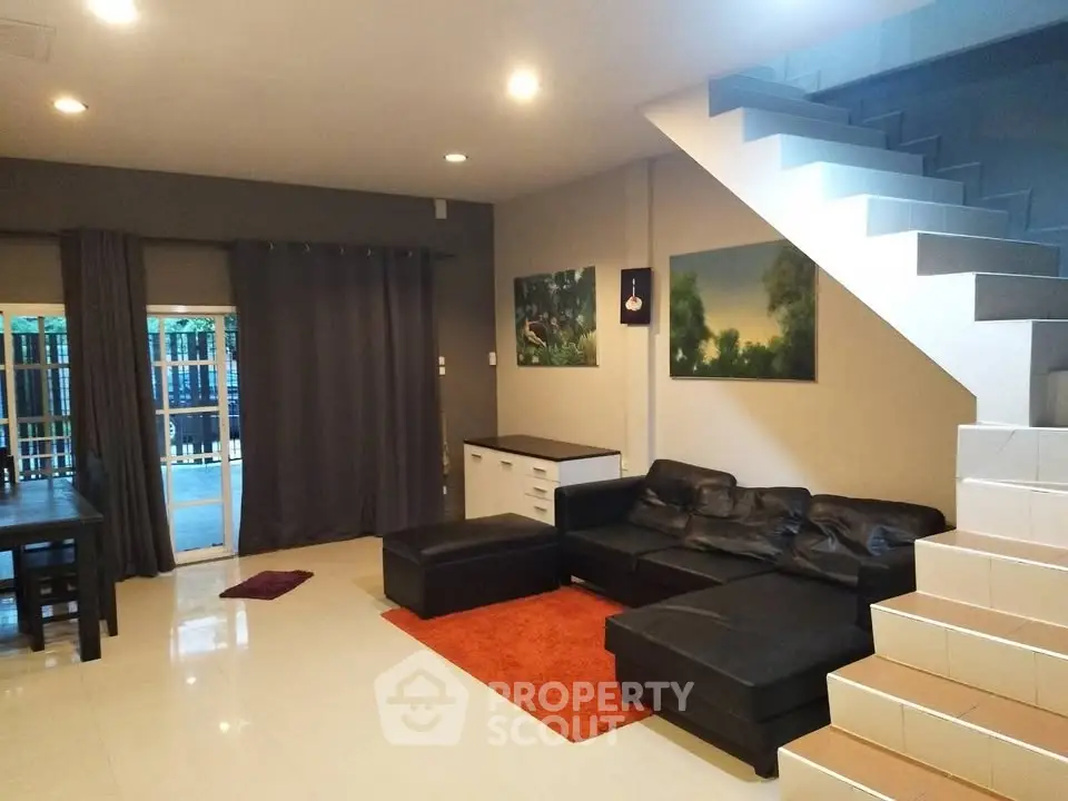 Spacious living room with modern decor and staircase, perfect for family gatherings.
