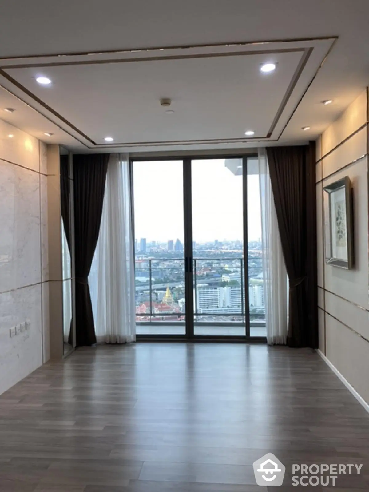 Spacious modern living room with floor-to-ceiling windows and city view