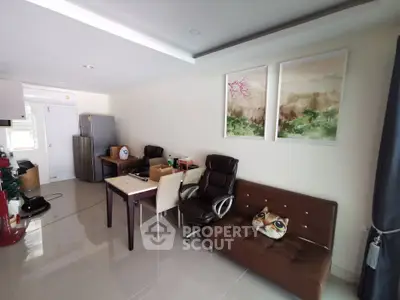 Modern living room with sleek furniture and open kitchen layout, perfect for cozy gatherings.