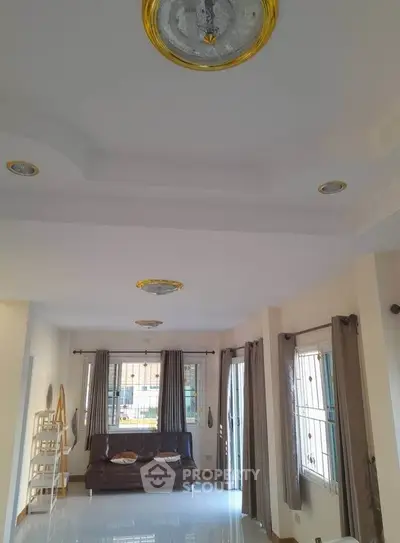 Spacious living room with elegant ceiling design and ample natural light.