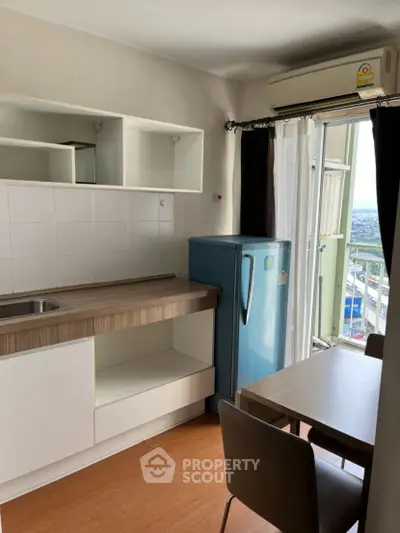 Modern kitchen with compact layout and city view from balcony