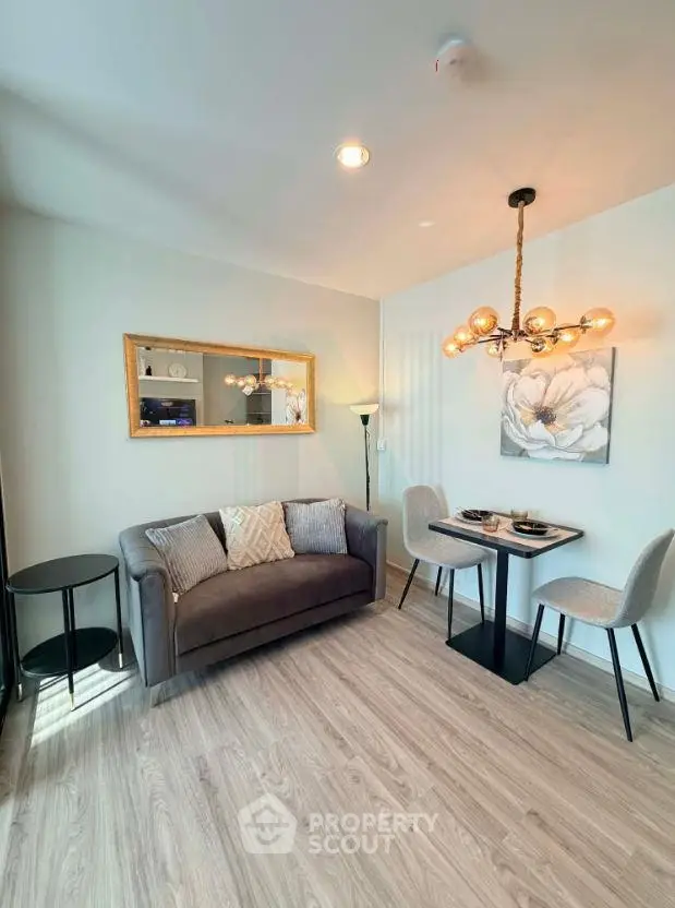 Modern living room with stylish decor and dining area, featuring elegant lighting and cozy seating.