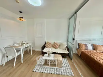 Modern open-plan living room with cozy dining area and adjacent bedroom