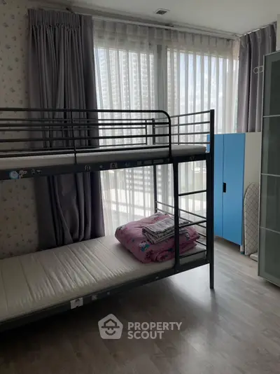 Modern bedroom with bunk bed and large windows in high-rise apartment