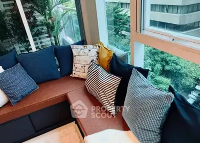 Cozy window seating area with plush cushions and lush greenery view, perfect for relaxation.