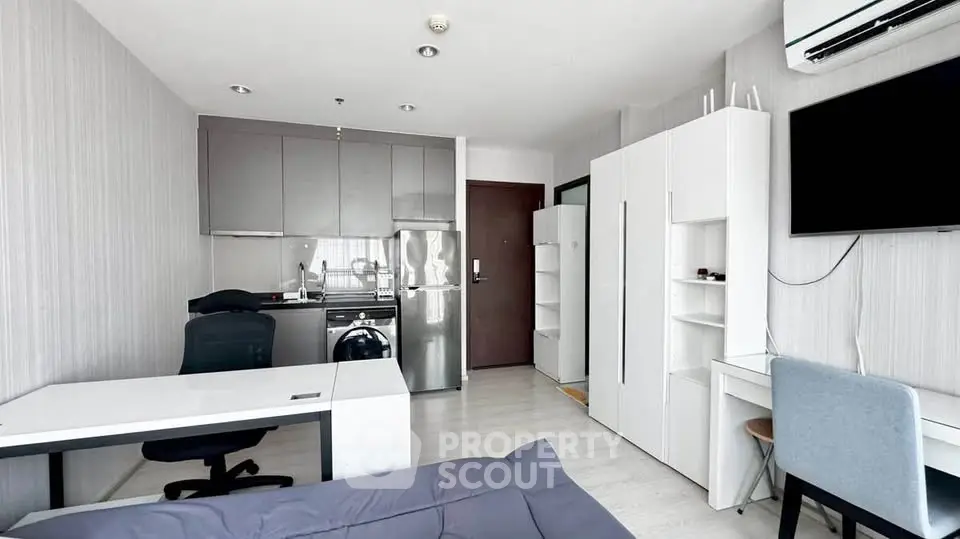 Modern studio apartment with sleek kitchen and workspace, ideal for urban living.