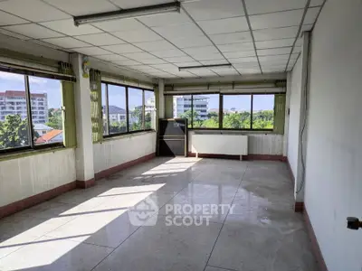 Spacious empty room with large windows offering a scenic view of the cityscape.