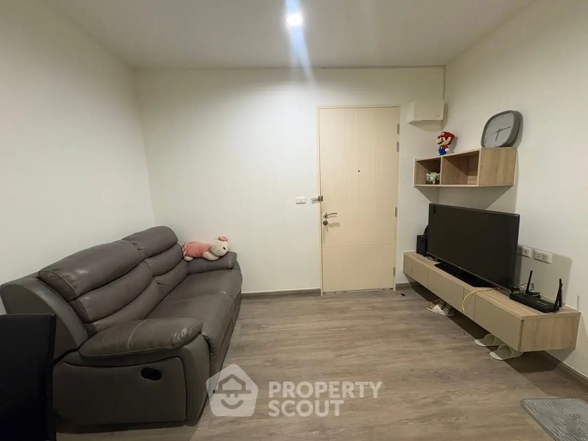 Cozy living room with modern sofa and entertainment setup, perfect for relaxation.