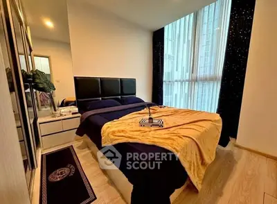 Cozy modern bedroom with large window and stylish decor in urban apartment.