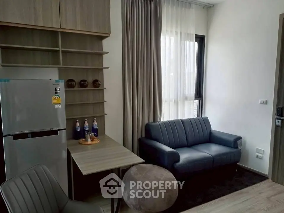 Modern living room with sleek furniture and natural light, featuring a compact dining area and stylish decor.