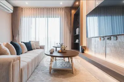 Luxurious modern living room with elegant decor and large TV, perfect for relaxation and entertainment.