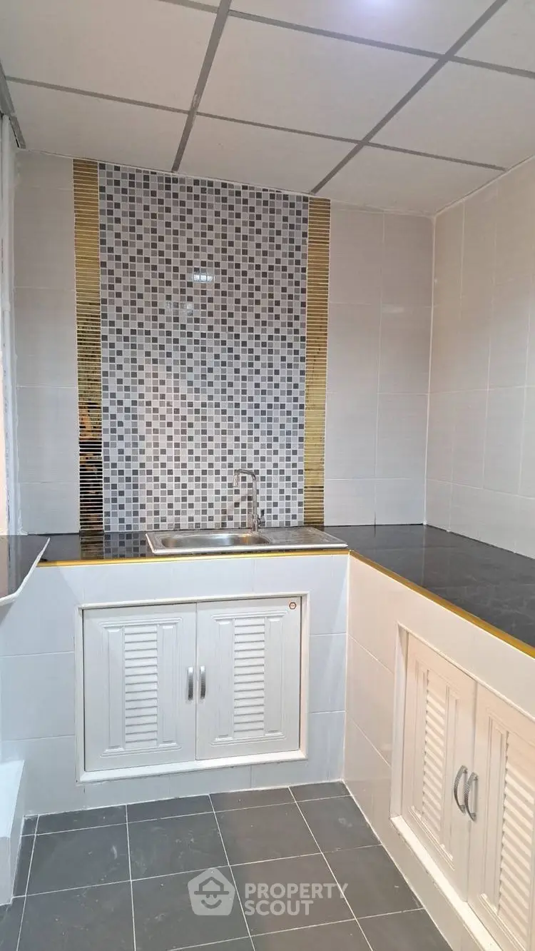 Modern kitchen with sleek tile backsplash and ample storage space.