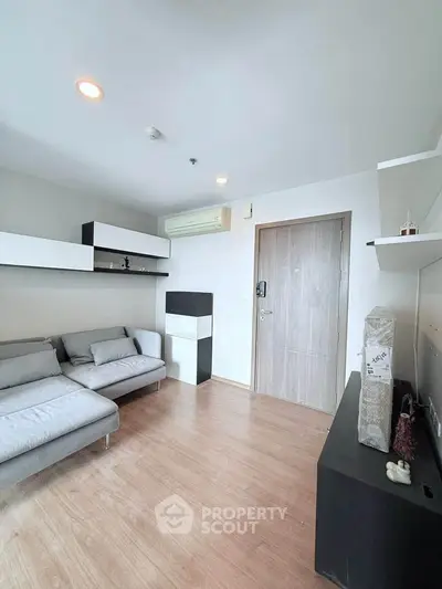 Modern living room with sleek furniture and wooden flooring in a stylish apartment.