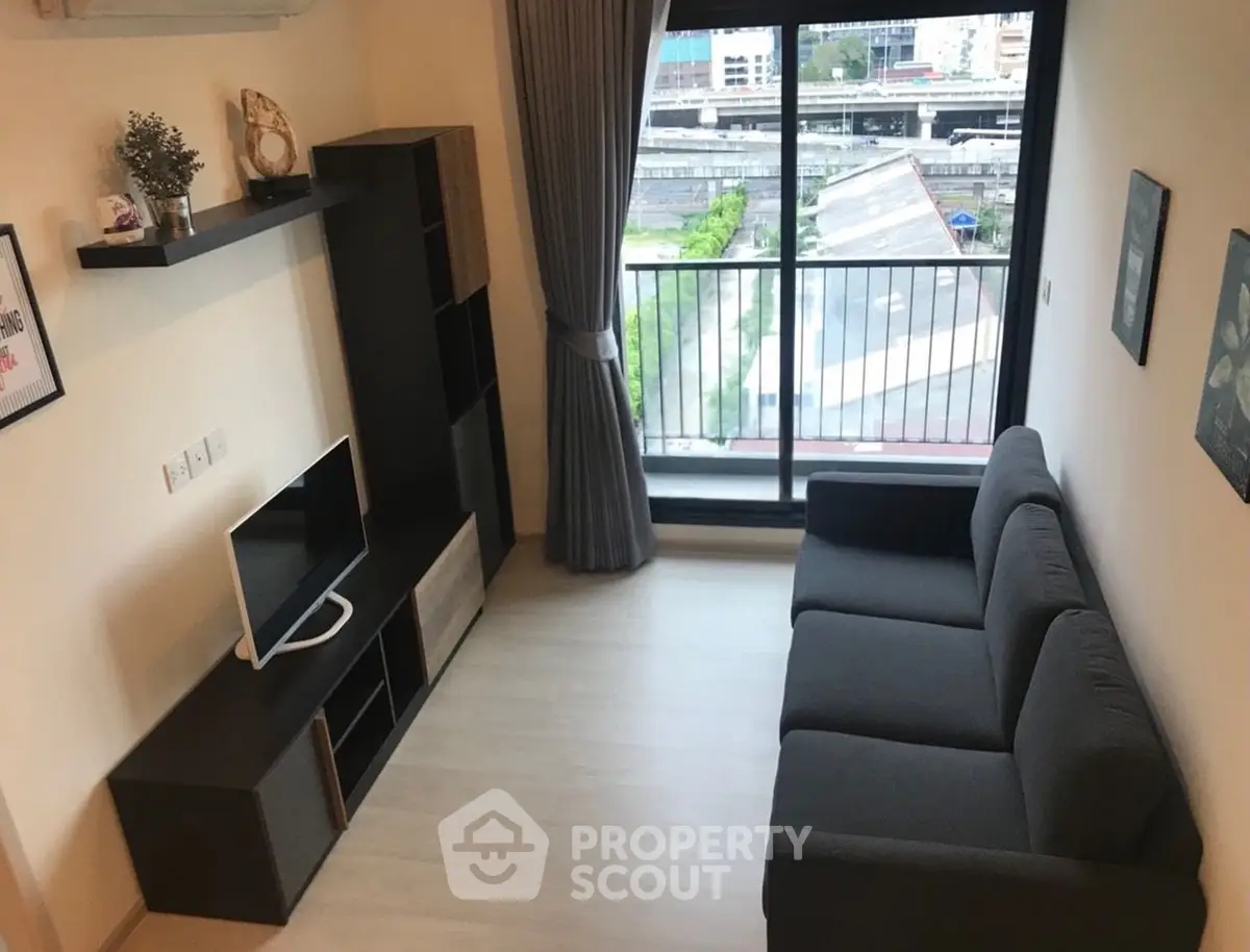 Modern living room with sleek furniture and city view from balcony, perfect for urban living.