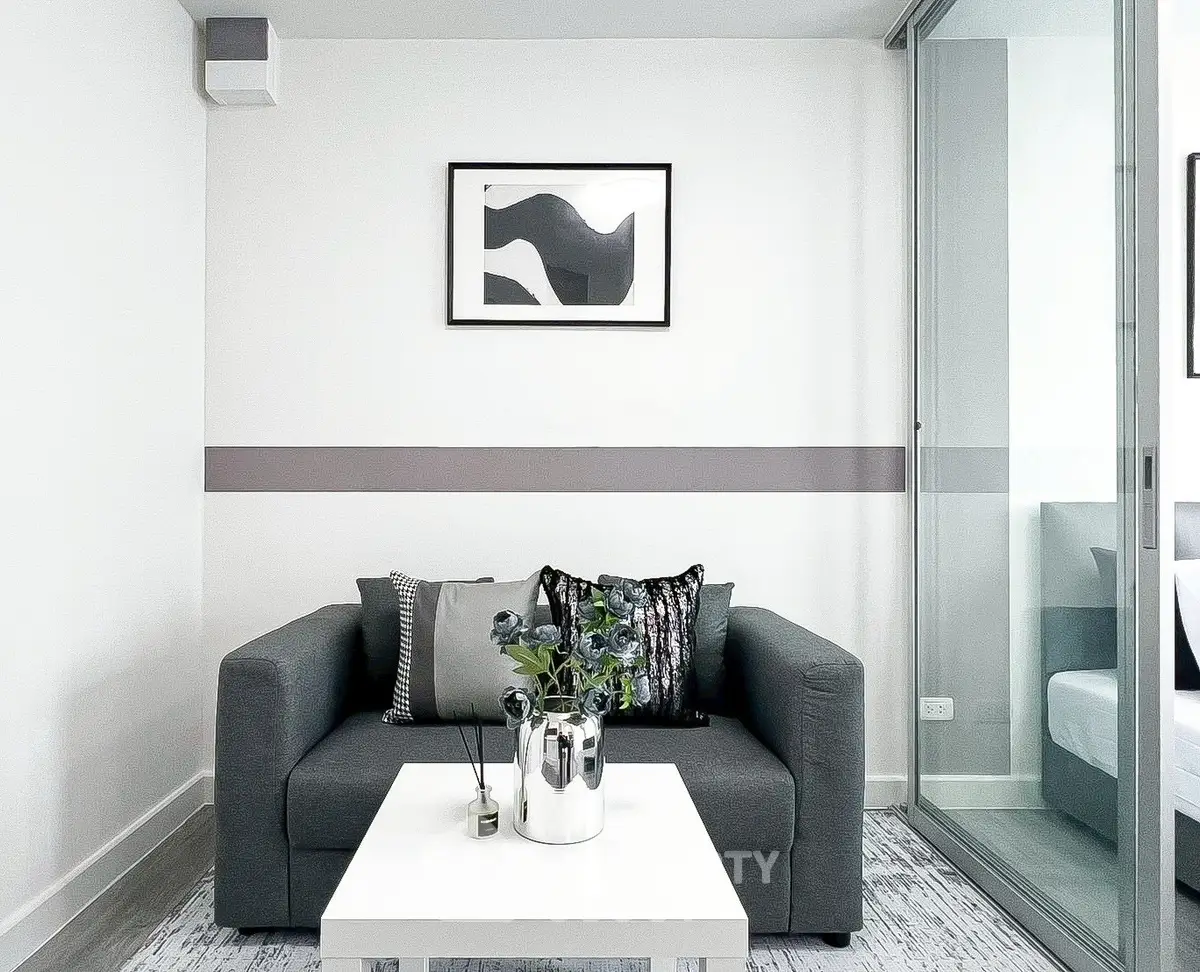 Modern living room with sleek gray sofa and stylish decor in a contemporary apartment.