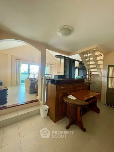 Spacious living room with modern staircase and elegant wooden furniture
