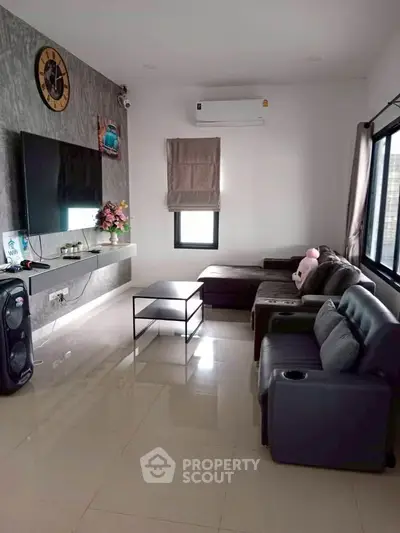 Modern living room with sleek furniture and wall-mounted TV, perfect for relaxation and entertainment.