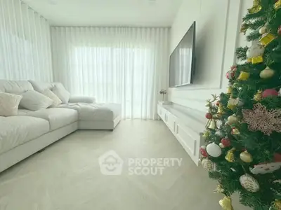 Elegant living room with cozy white sofa and festive Christmas tree, perfect for holiday gatherings.