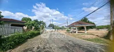 Charming residential street with gazebo and lush greenery under a bright blue sky.