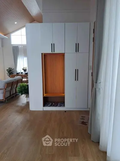 Modern living room with stylish wooden flooring and built-in storage unit