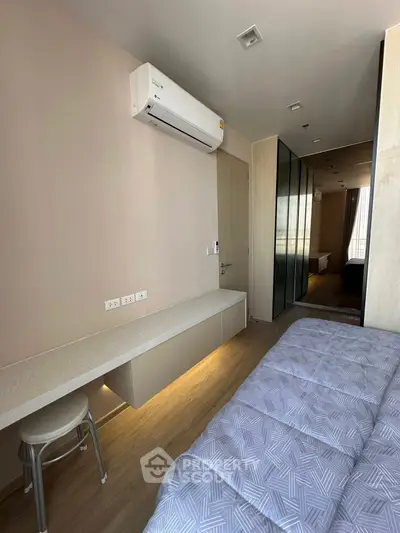 Modern bedroom with sleek design, featuring built-in storage and air conditioning, perfect for urban living.