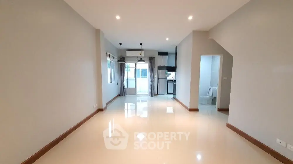 Spacious open-plan living area with modern kitchen and sleek flooring