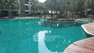 Luxurious residential pool surrounded by lush greenery and modern architecture.