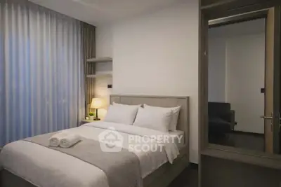 Modern bedroom with cozy bed and ambient lighting in a stylish apartment.