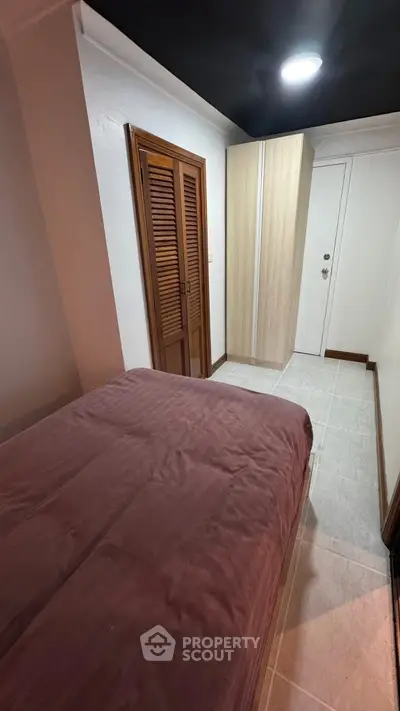 Cozy bedroom with wooden closet and modern lighting, perfect for restful nights.
