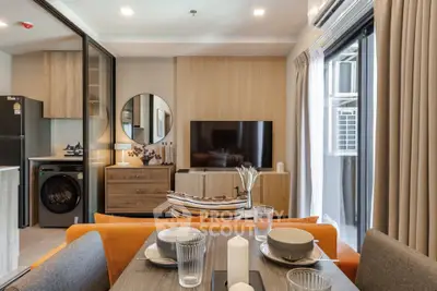 Modern living room with open kitchen, stylish decor, and natural light