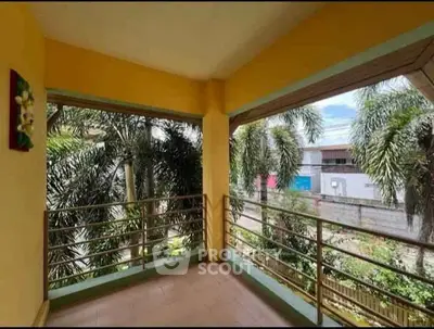 Spacious balcony with lush greenery and street view, perfect for relaxation and enjoying the outdoors.