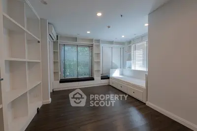 Spacious modern living room with built-in shelves and large windows