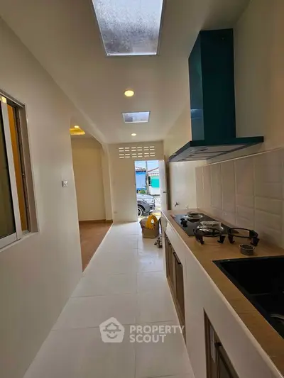 Modern kitchen with gas stove and sleek design, featuring ample natural light and open layout.