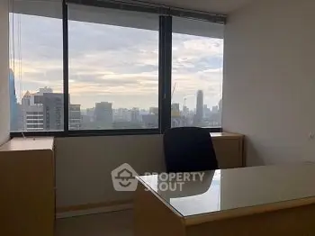 Modern office space with city view and large window, ideal for productivity.