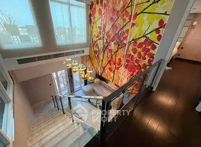 Luxurious modern staircase with vibrant wall art and elegant lighting in upscale home