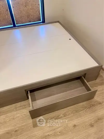 Modern bedroom with built-in storage bed frame and wooden flooring