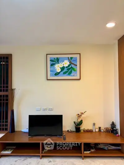 Modern living room with stylish TV stand and floral artwork, perfect for cozy evenings.