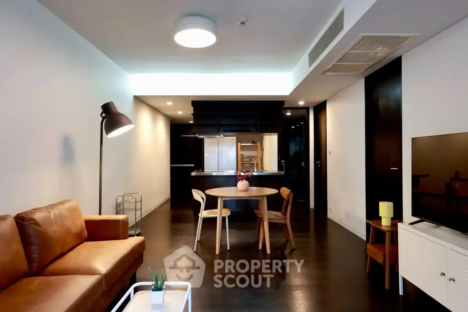 Modern living room with stylish furniture and open kitchen layout in a contemporary apartment.